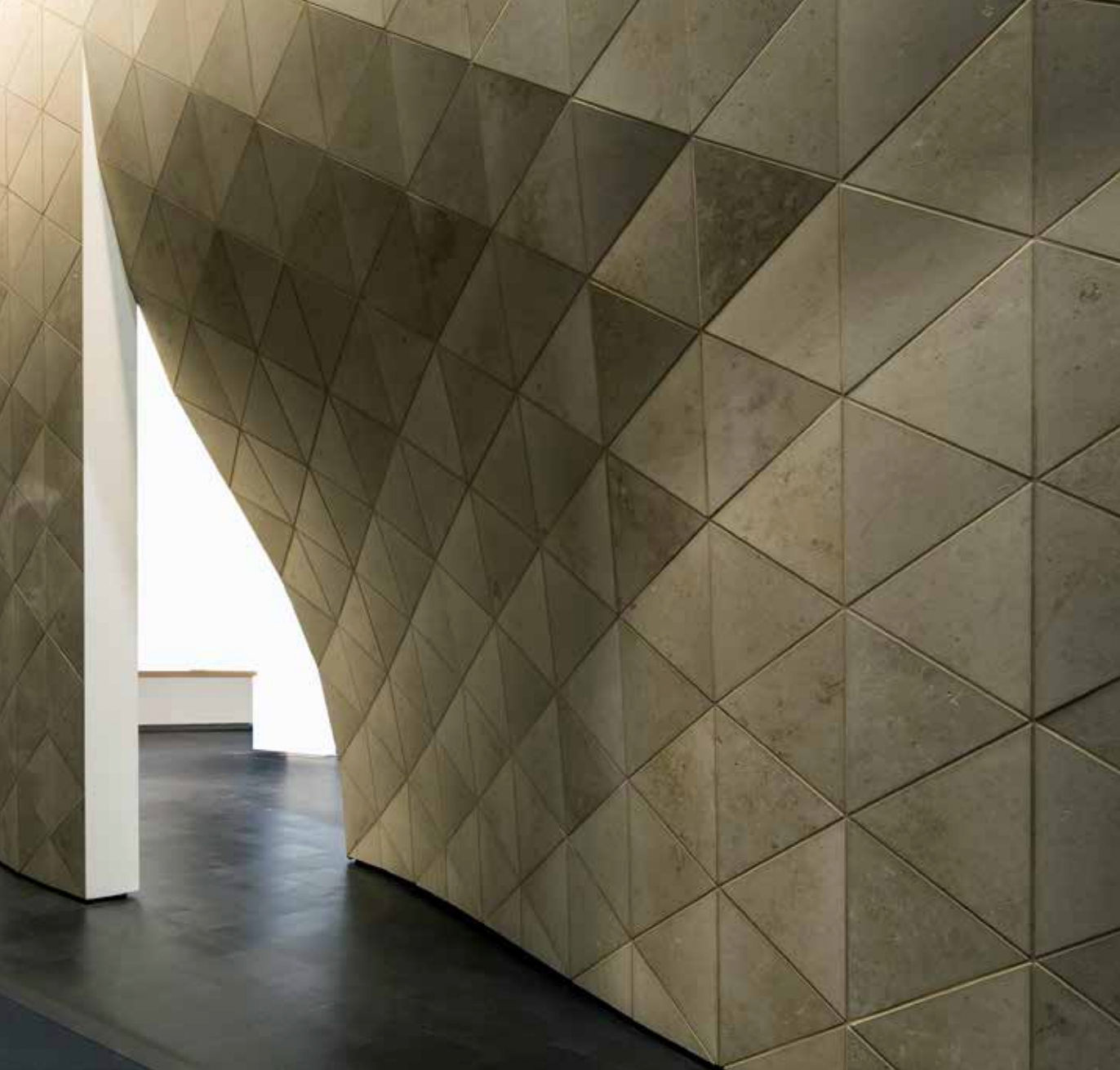 Curved architectural wall featuring StoVentec Natural Stone finish rainscreen panels, showcasing elegant texture and durable exterior cladding for modern building design