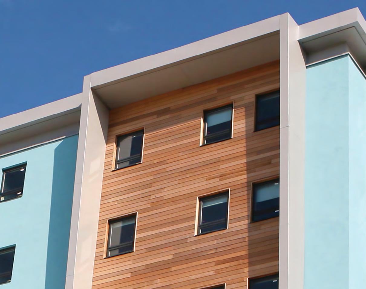 Stocast wood cladding featured in multi-finish exterior design, adding warm contrast and organic texture to architectural facade system