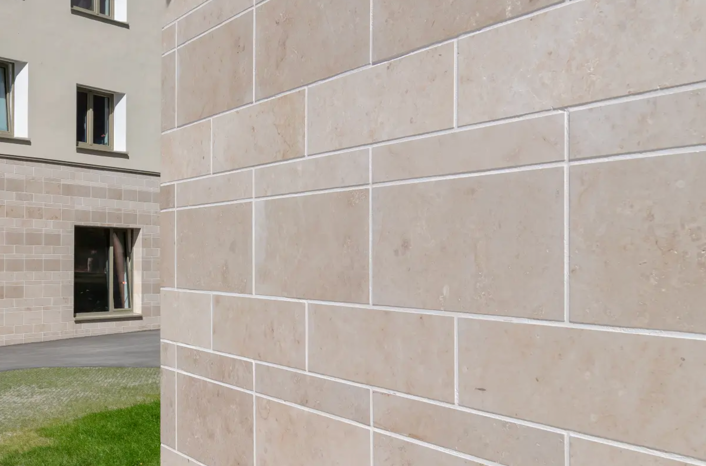 Wide-angle image of a building facade clad with StoVentec Natural Stone finish, highlighting the distinctive block-pattern texture and durable rainscreen system for architectural applications on apartment building