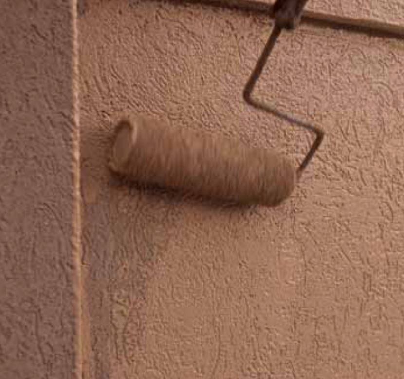 StoColor Lotusan paint hydrophobic self-cleaning coating being applied with roller on exterior wall surface