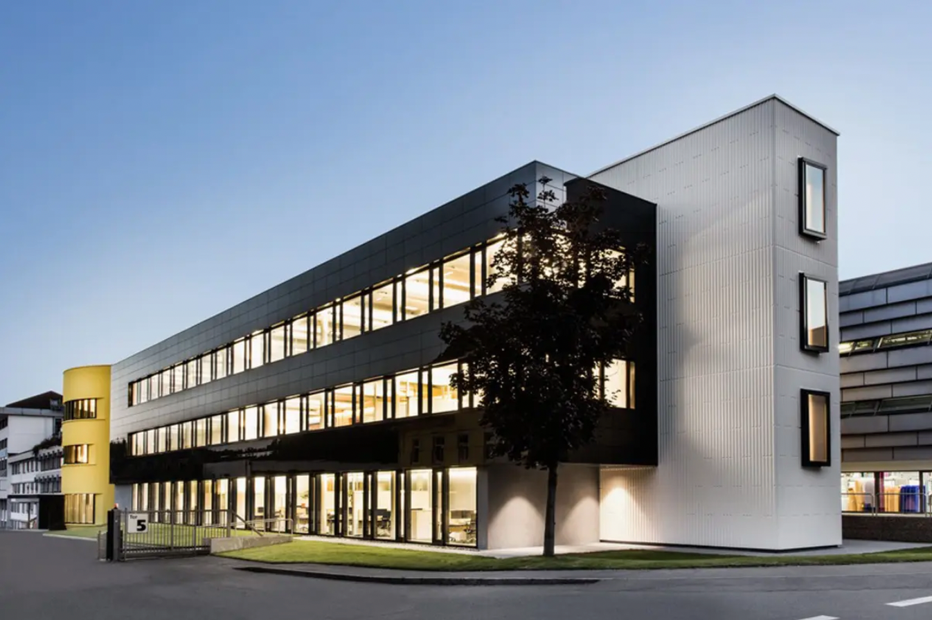 Contemporary commercial office building clad in black StoVentec Glass panels, showcasing sleek rainscreen facade design with high-performance energy efficiency.