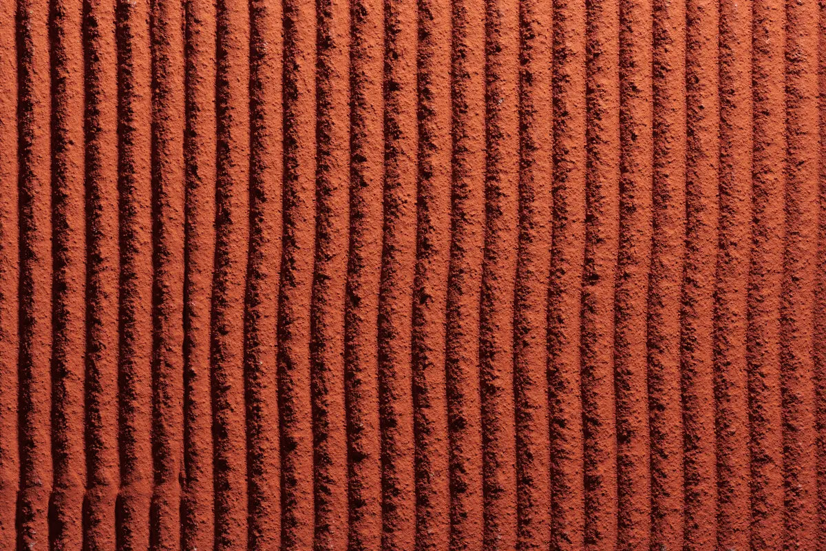 Sto stucco finish in rich red brick tone with vertically applied triangle notch trowel texture, showing creative acrylic stucco design possibilities for EIFS and rainscreen façades