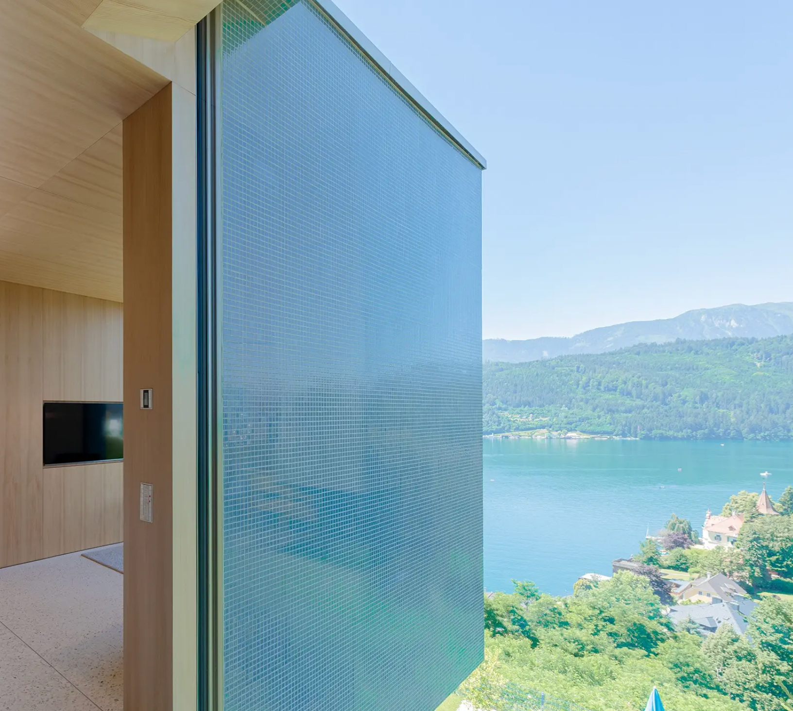 StoVentec glass mosaic rainscreen façade on modern home overlooking scenic mountain landscape, combining vibrant design with high-performance cladding