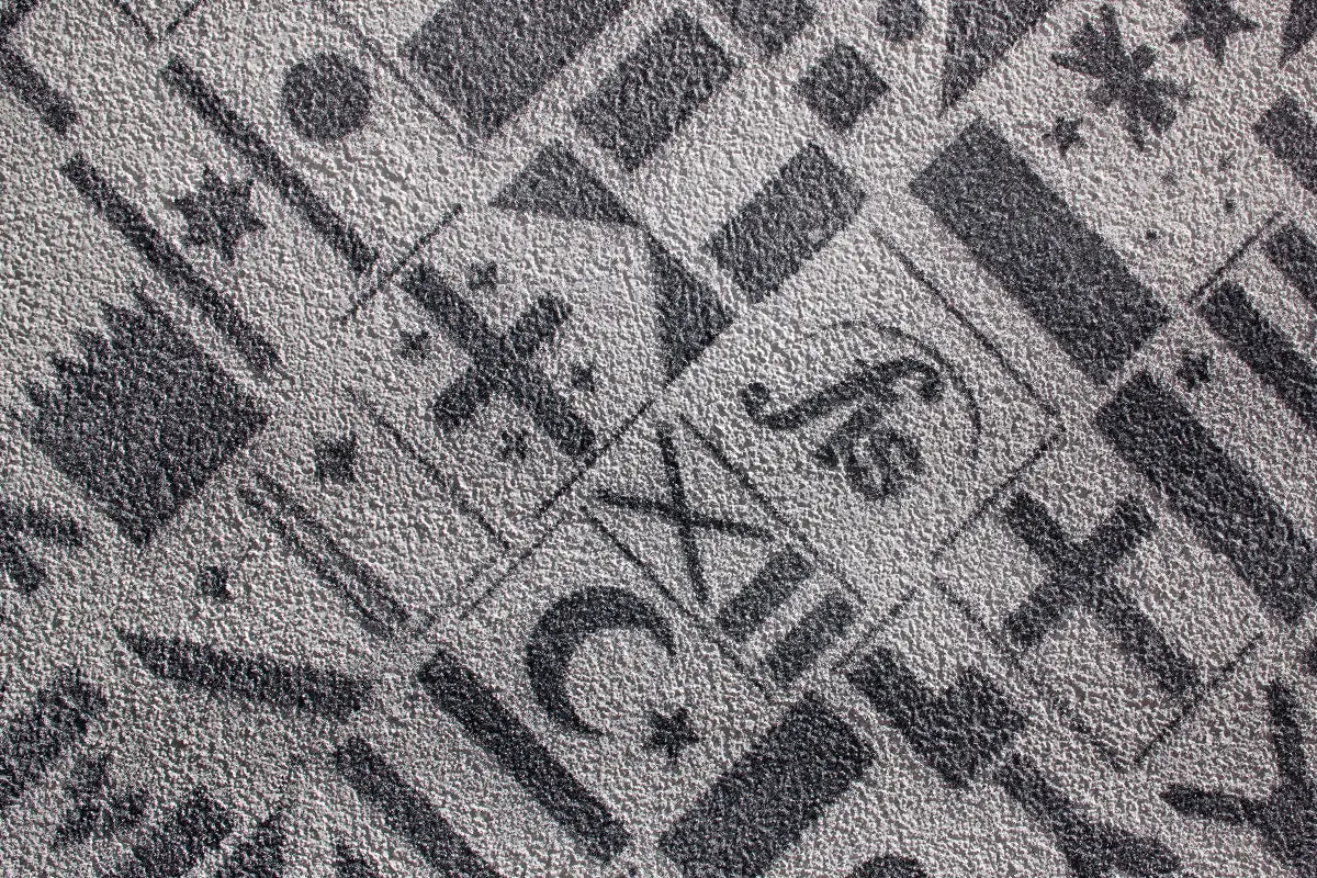 Close-up of Sto stucco surface featuring textured finishes in the patterns of various country flags, demonstrating creative design flexibility for EIFS and rainscreen applications